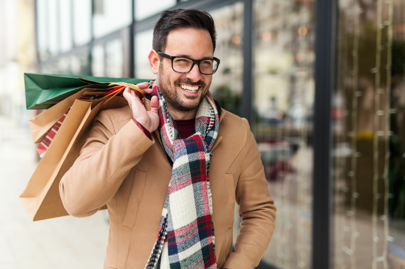 Man with shop bag smiling